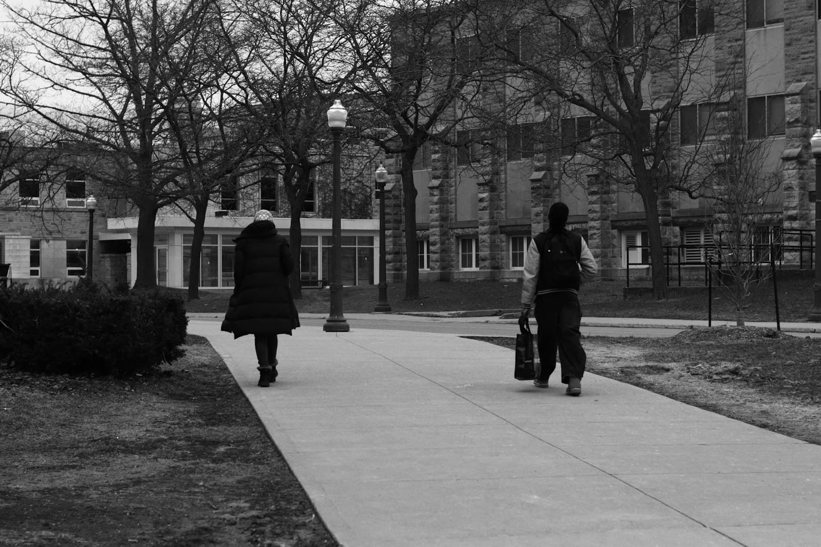 Two people walk down a paved path outdoors — Photo by Jaykumar Bherwani on Unsplash