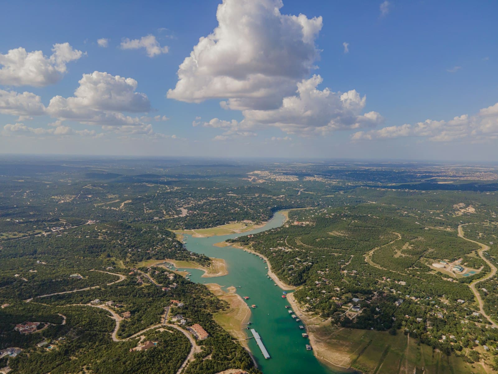 aerial view of green field and body of water during daytime — Photo by Conner Baker on Unsplash